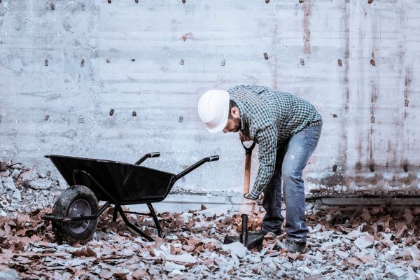 a-latin-bricklayer-picks-up-debris-in-a-black-whee-2025-01-07-06-13-06-utc (1)